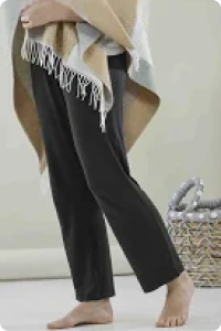 A barefoot woman wears the loose leg jersey pull on trousers